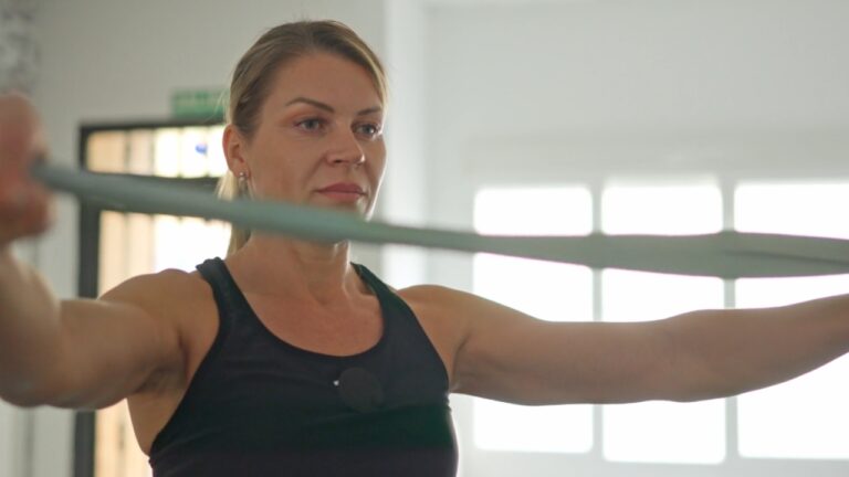 Woman uses a resistance band during a focused gym workout