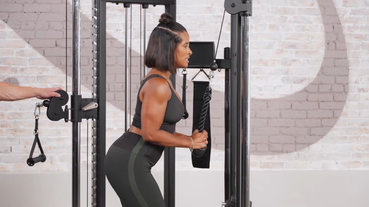 Woman performs a cable triceps pushdown on a Centr 2 home gym trainer