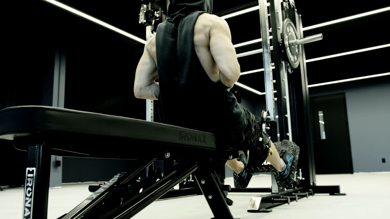 Man performs a seated cable row on an Ironax strength machine